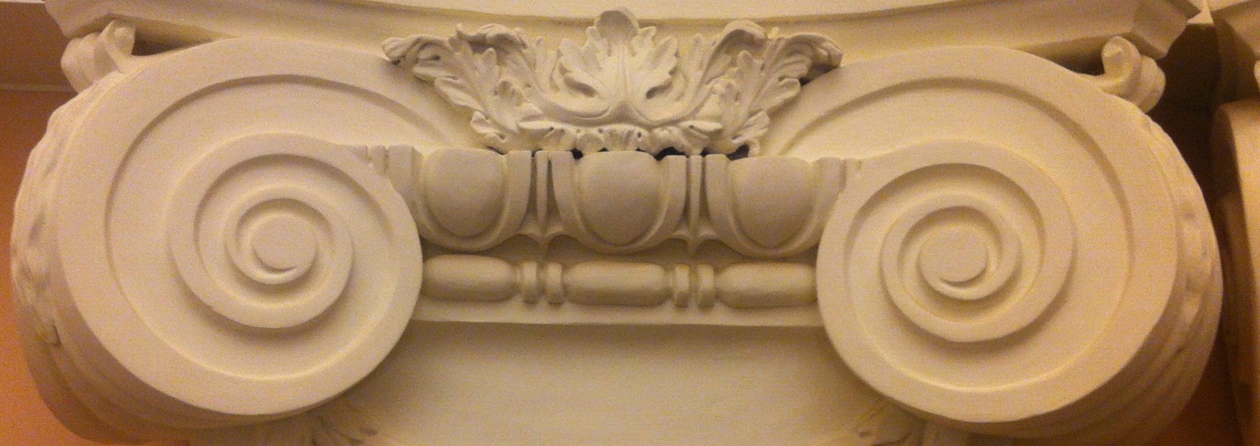 A detailed view of an Ionic column capital with intricate volutes and decorative carvings.